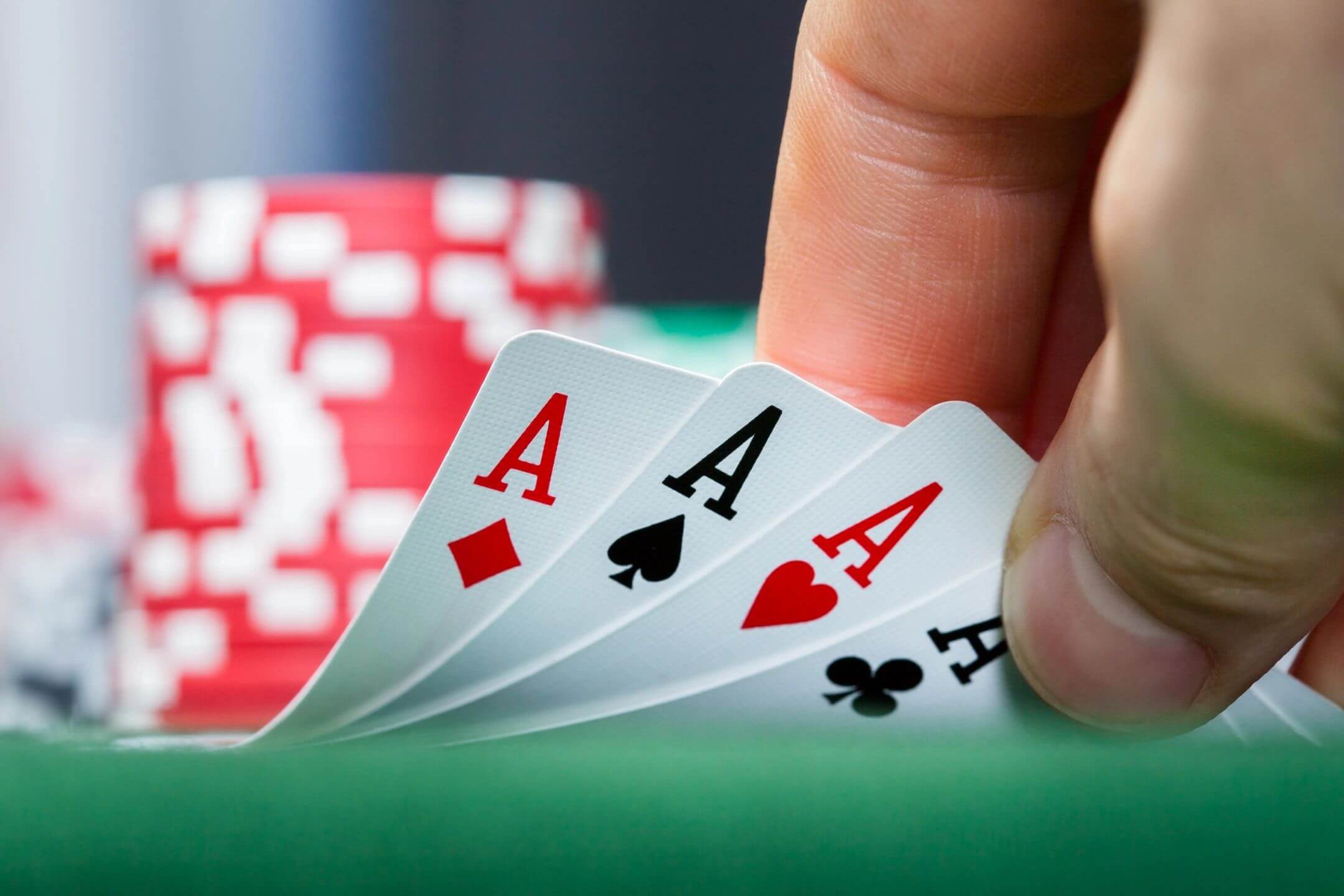 Corporate casino party rental in Milwaukee, WI - hand fanning four aces over green felt casino table